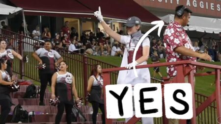 A screencap from a football game where a coach is wearing a red Hawaiian shirt from Candor Threads. There's an arrow pointing at him from the caption 'YES'.